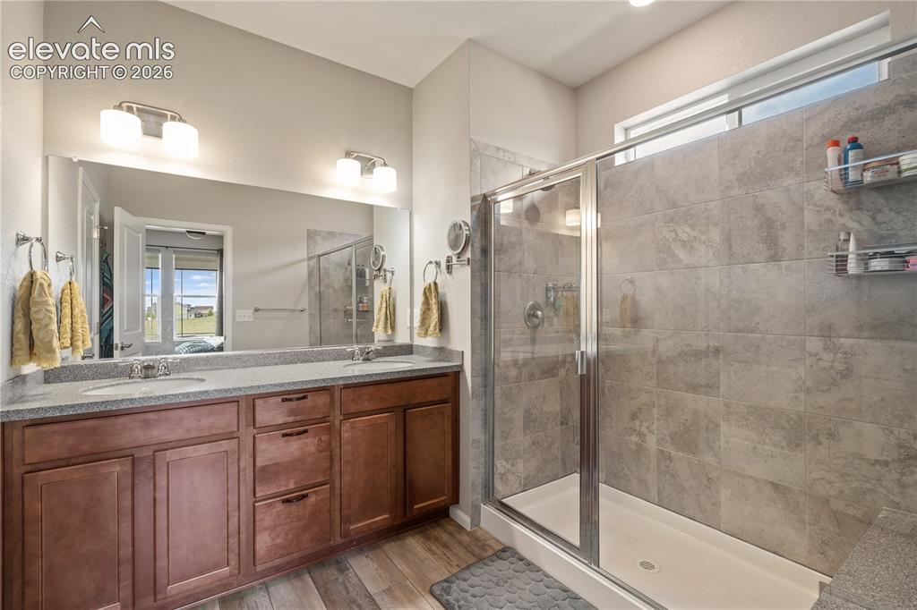 Image 23 of 38: Spacious bathroom featuring a double vanity with stone-finish countertop, w