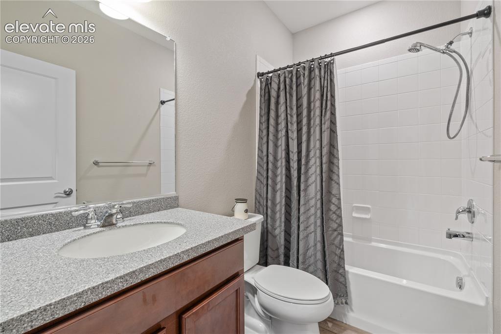 Image 26 of 38: Bathroom featuring a white subway tile shower, built-in bathtub, and a vani