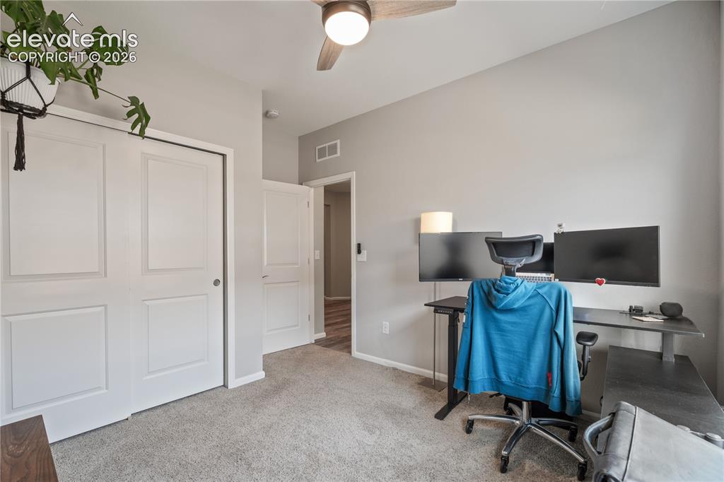 Image 28 of 38: Carpeted room with light gray walls, featuring a ceiling fan with integrate