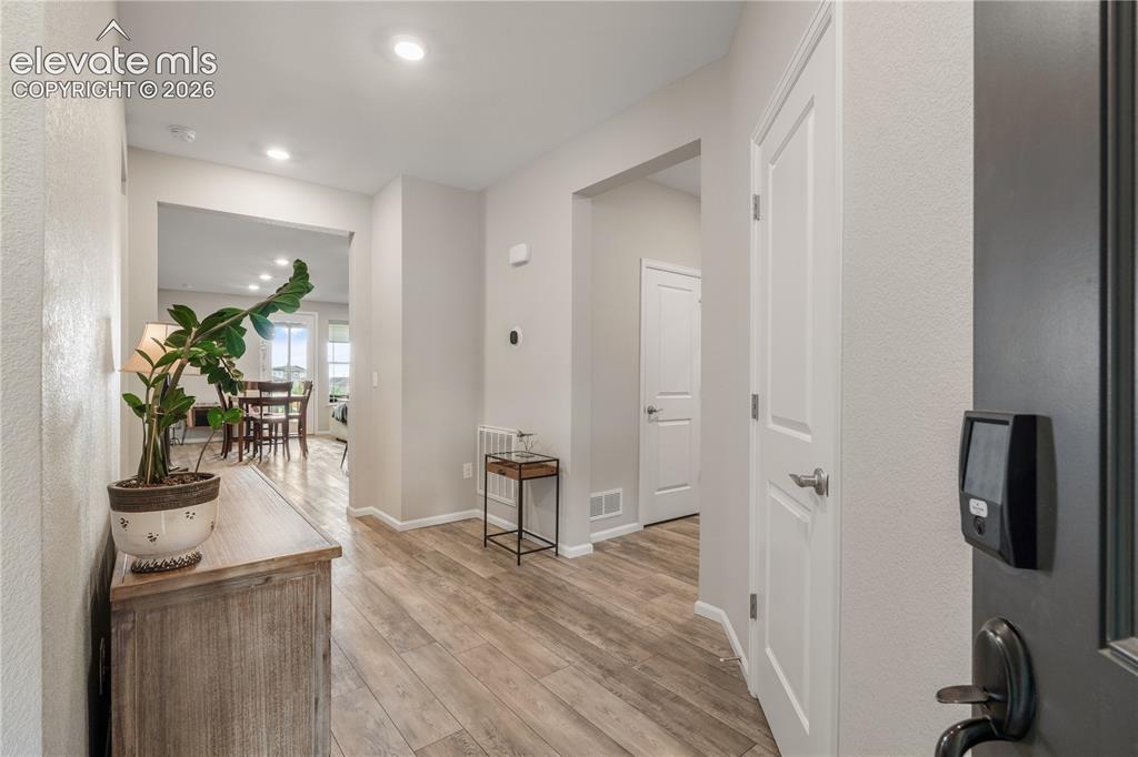 Image 4 of 38: Hallway entryway featuring wood-finish flooring, recessed lighting, neutral
