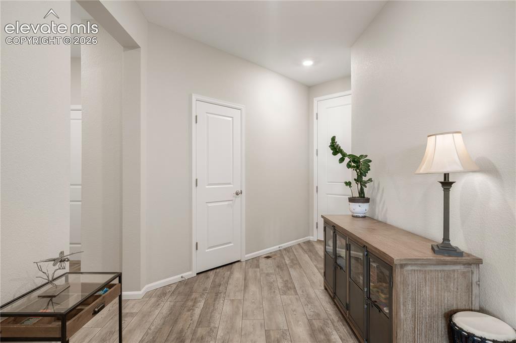 Image 5 of 38: Bright interior hallway featuring wood-finish flooring
