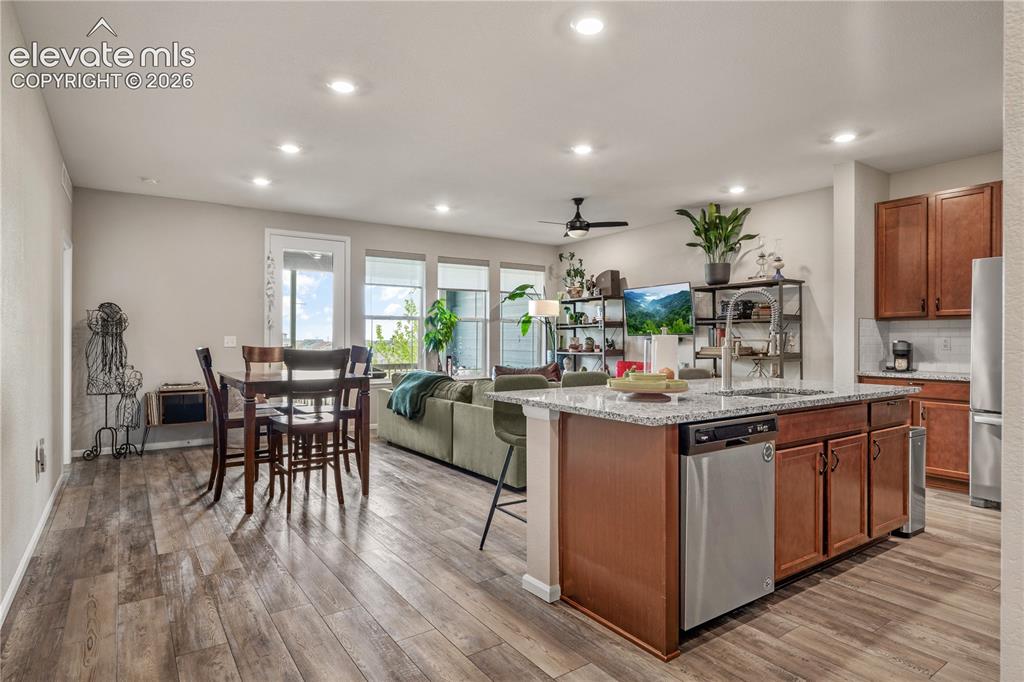 Image 6 of 38: Open-concept living space featuring wood-finish flooring, recessed lighting