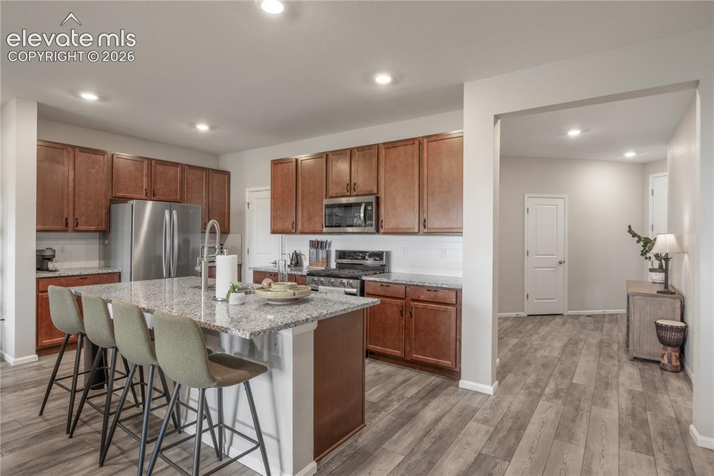 Image 7 of 38: Open-concept kitchen featuring an oversized island with seating, stainless 