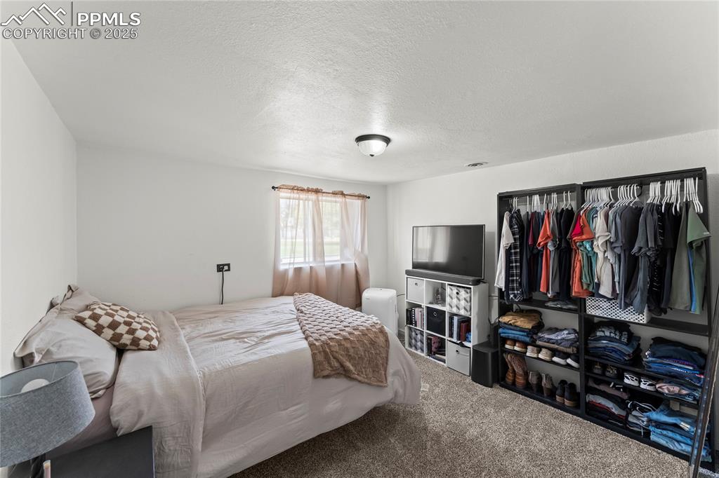 Image 12 of 26: Carpeted bedroom featuring a textured ceiling