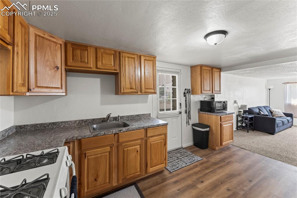 Image 14 of 26: Kitchen featuring a textured ceiling, white gas range oven, open floor plan