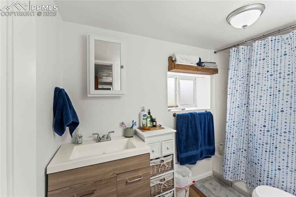 Image 17 of 26: Bathroom with shower / tub combo with curtain, vanity, and light wood-style