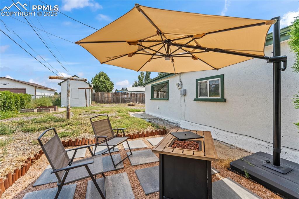 Image 24 of 26: View of patio / terrace with a fire pit and a storage shed