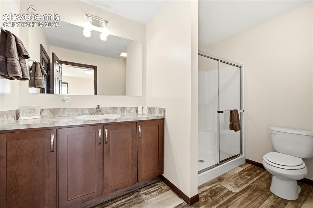 Image 12 of 26: Wood-finish flooring, a spacious vanity with an integrated sink, a large wa