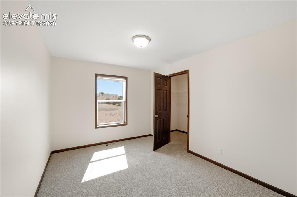 Image 13 of 26: Neutral wall paint with contrasting dark wood-finish trim and doors