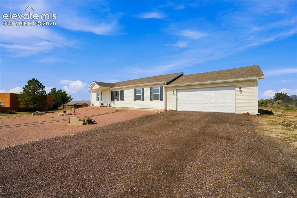Image 20 of 26: Single-story residence featuring light-colored siding, a front porch with w