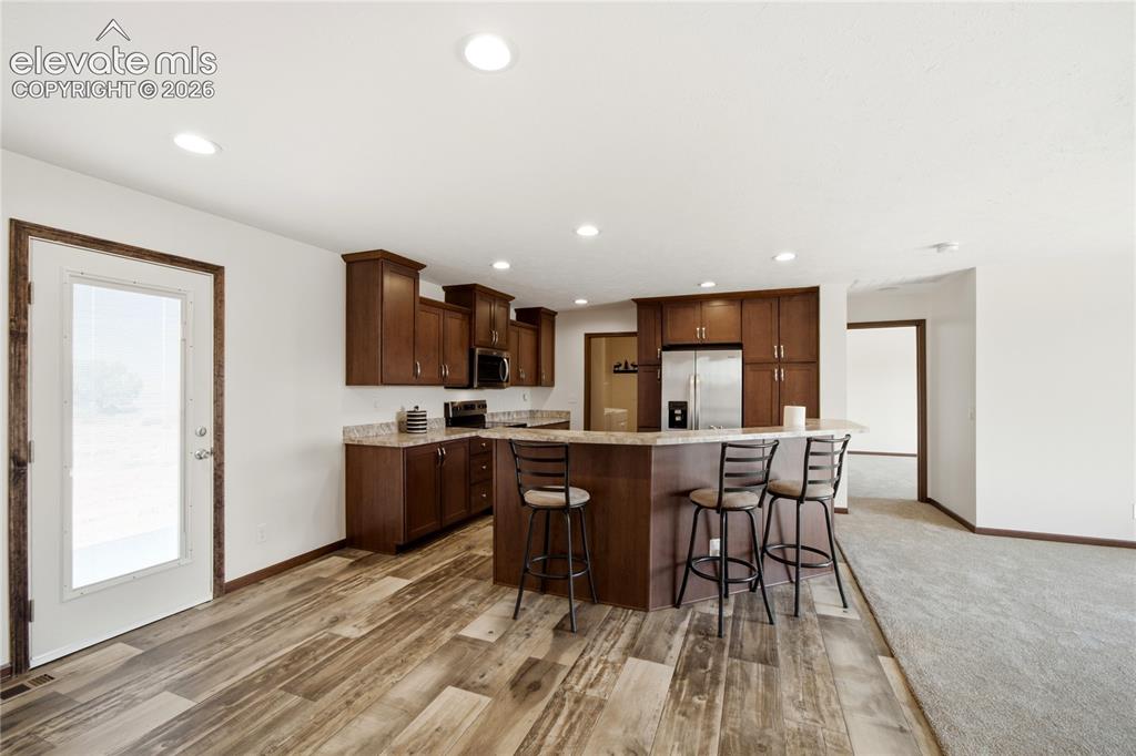 Image 7 of 26: Kitchen featuring wood-finish flooring, recessed lighting, wood cabinetry, 