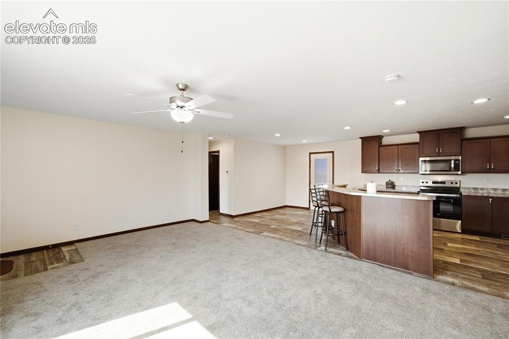 Image 7 of 26: Open-concept living and kitchen area featuring recessed ceiling lighting, c