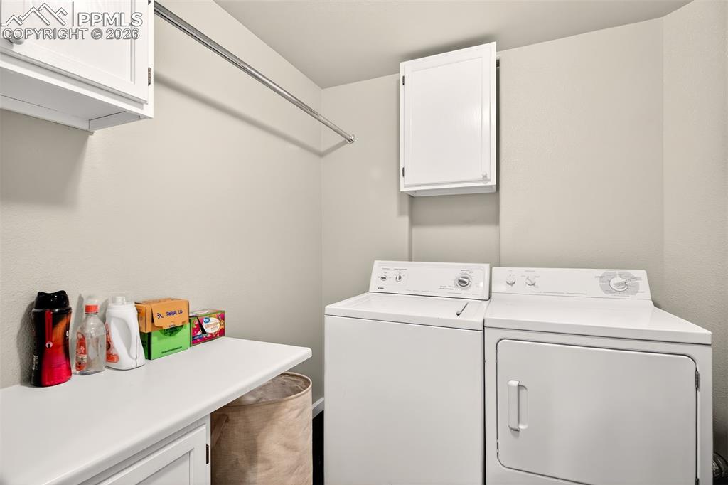 Image 19 of 35: large 8 x 8 laundry with cabinets and hanging rod