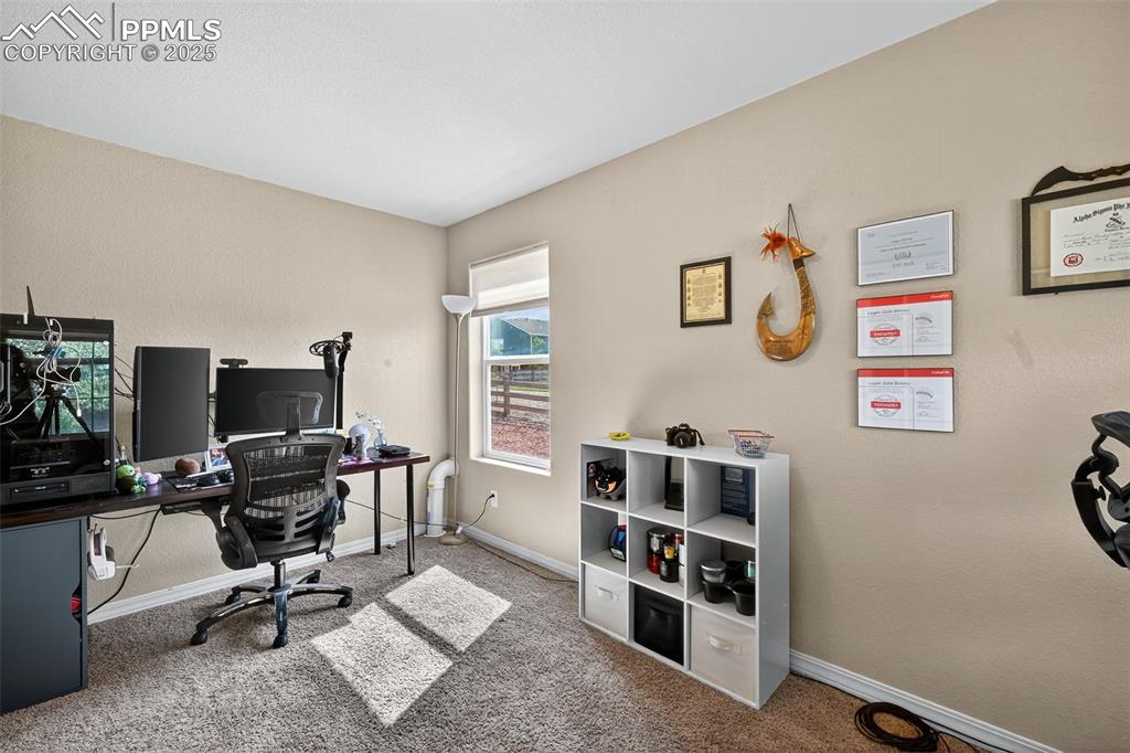 Image 19 of 33: Home office with carpet flooring and baseboards
