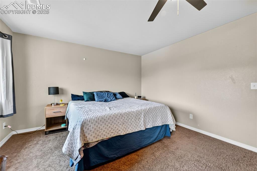 Image 21 of 33: Carpeted bedroom with ceiling fan and baseboards