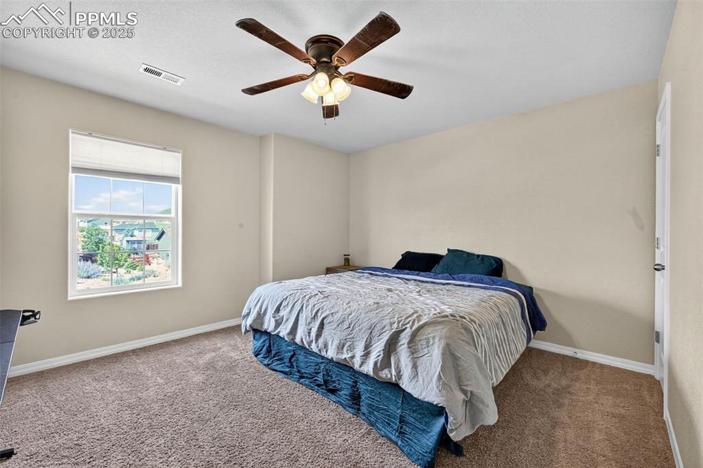 Image 25 of 33: Carpeted bedroom with baseboards and a ceiling fan