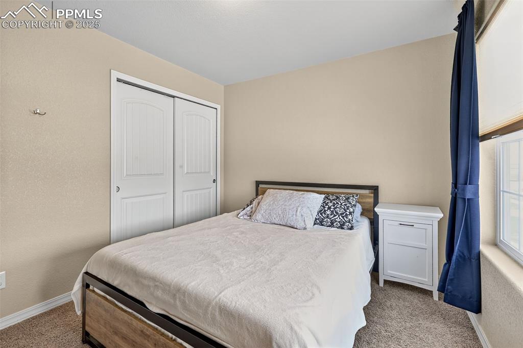 Image 29 of 33: Bedroom with carpet flooring, a closet, and a textured wall