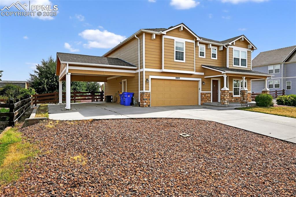Image 3 of 33: View of front facade with stone siding, concrete driveway, a shingled roof,