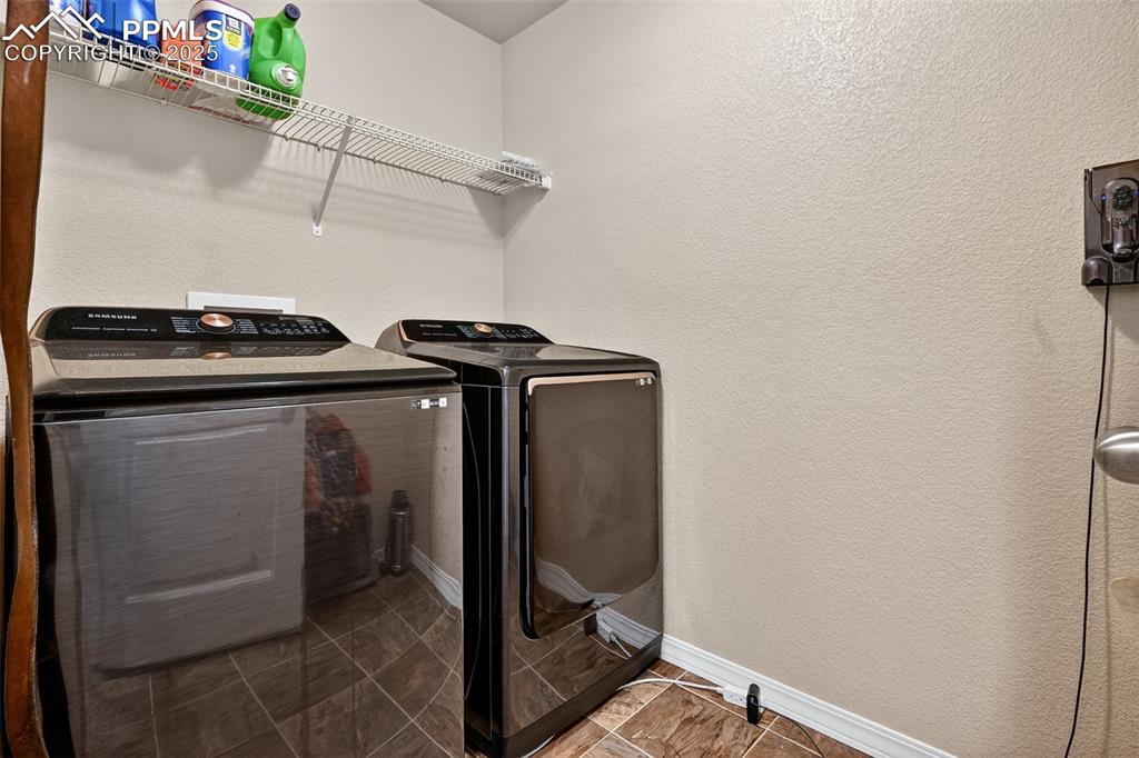 Image 30 of 33: Washroom featuring a textured wall and washer and clothes dryer