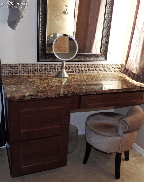 Image 14 of 19: Bathroom with decorative backsplash, tile patterned floors, and vanity
