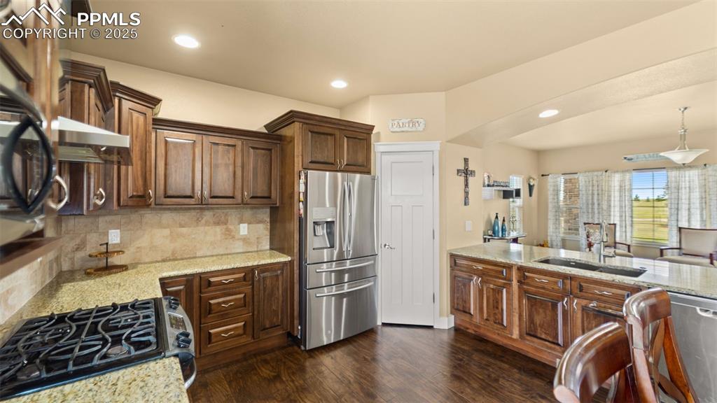 Image 10 of 50: Kitchen with appliances with stainless steel finishes, tasteful backsplash,