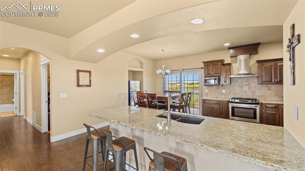 Image 13 of 50: Kitchen featuring appliances with stainless steel finishes, wall chimney ex