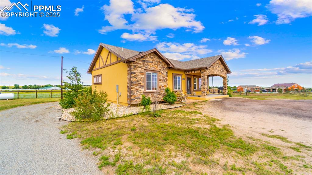 Image 2 of 50: View of front of property featuring stone siding, stucco siding, and a shin