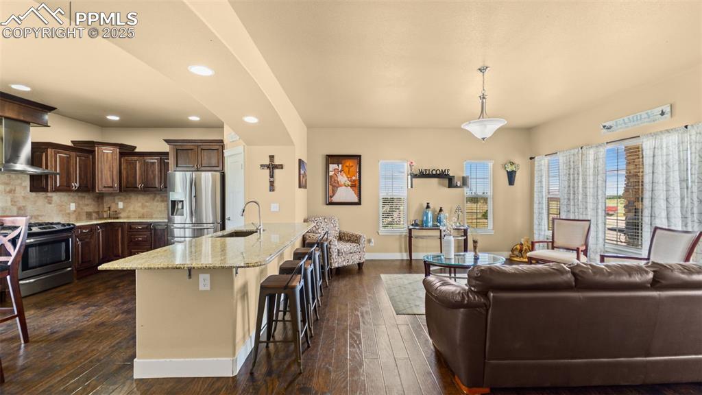 Image 22 of 50: Kitchen with appliances with stainless steel finishes, dark brown cabinetry