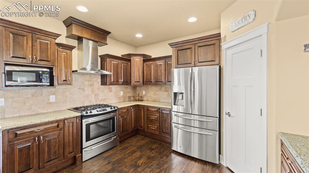 Image 8 of 50: Kitchen with appliances with stainless steel finishes, tasteful backsplash,