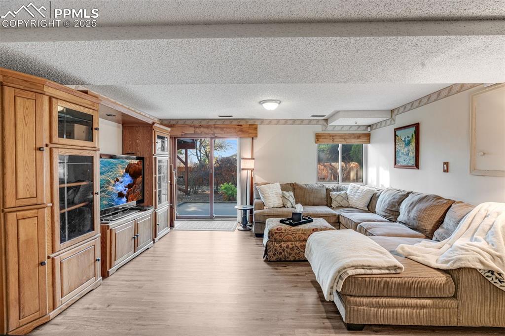 Image 23 of 41: Living room featuring a walkout patio to beautifully landscaped backyard. 