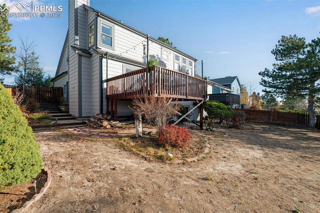 Image 30 of 41: Back of property - stairs lined with perennial flower beds leading down to 