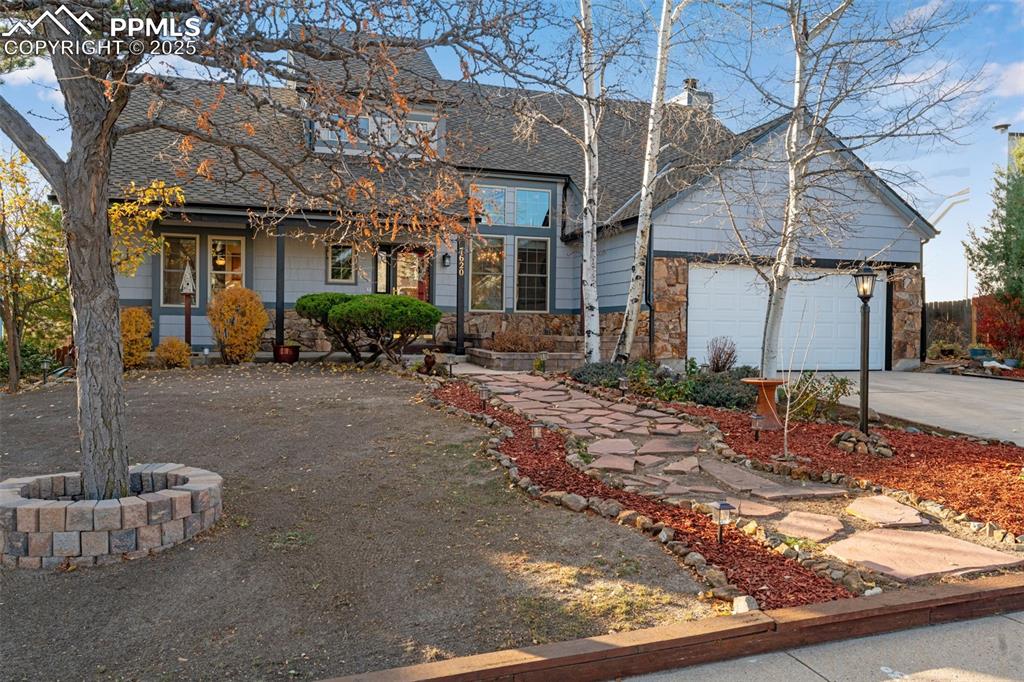 Image 32 of 41: Traditional home with driveway, covered porch, roof with shingles, a garage