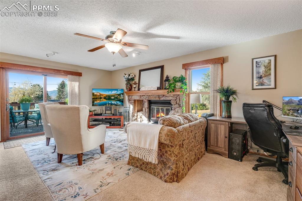 Image 8 of 41: Spacious living room with wood burning fireplace and deck access. 