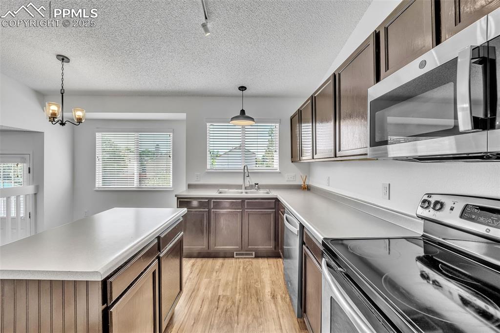 Image 10 of 43: Kitchen featuring stainless steel appliances, light wood-style floors, ligh