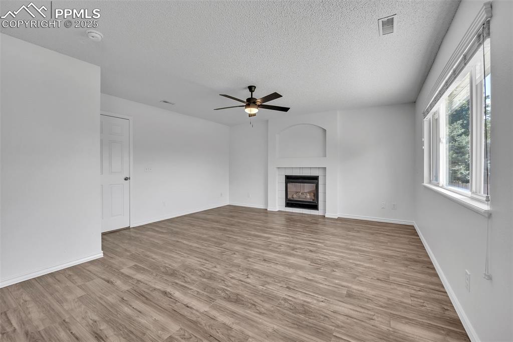 Image 13 of 43: Unfurnished living room featuring light wood-style floors, a tile fireplace