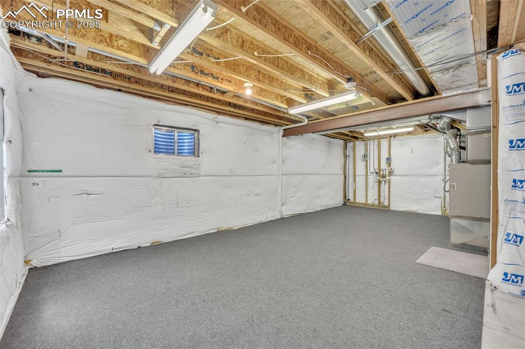 Image 16 of 43: Unfinished basement with heating unit