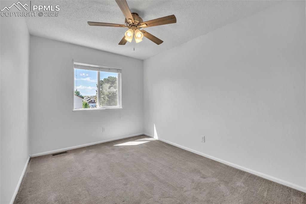 Image 21 of 43: Unfurnished room featuring carpet, a textured ceiling, and a ceiling fan