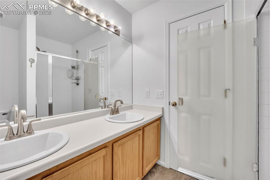 Image 29 of 43: Full bathroom featuring a stall shower and double vanity