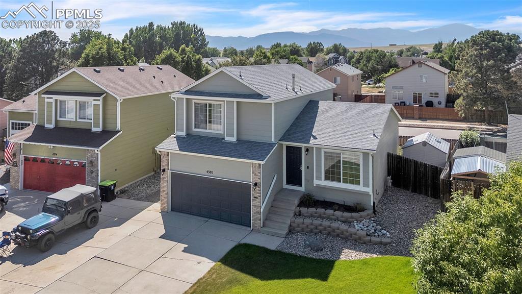 Image 32 of 43: View of front facade featuring a residential view, a garage, roof with shin