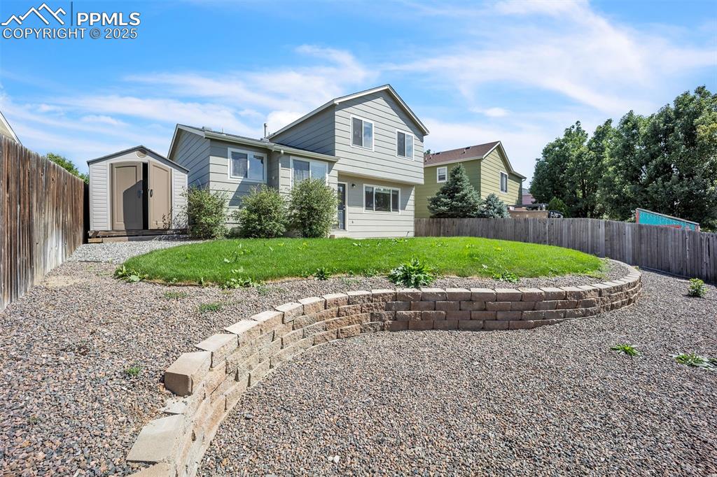 Image 4 of 43: Back of property with a fenced backyard and a shed