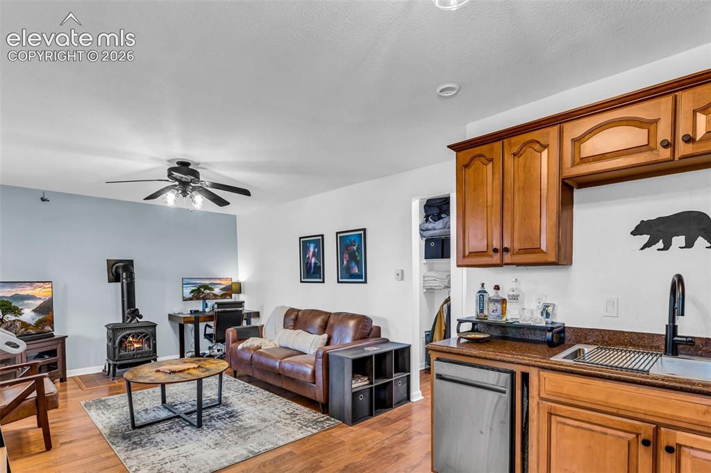 Image 10 of 37: Open-concept living area featuring wood-finish flooring, a ceiling fan with