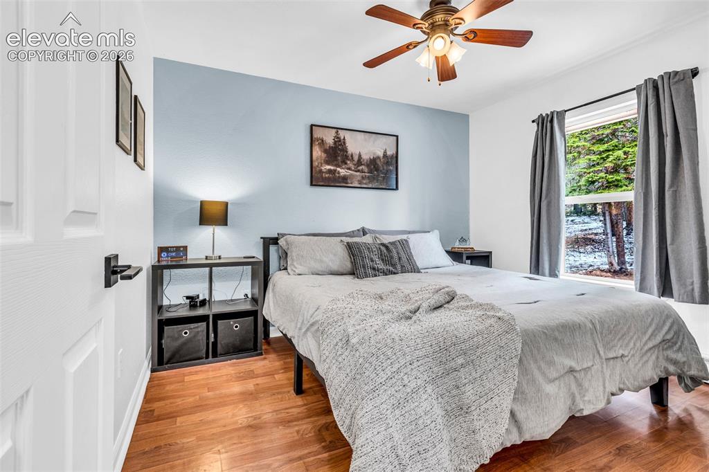 Image 13 of 37: Room featuring wood-finish flooring, a ceiling fan with integrated lighting