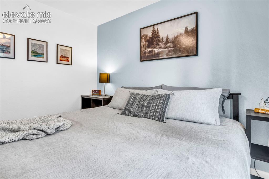 Image 16 of 37: Bedroom featuring a two-tone wall design, a built-in headboard, and a bedsi
