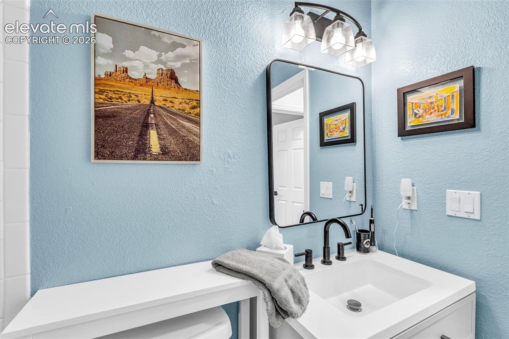 Image 20 of 37: Vanity featuring a rectangular undermount sink, matte black faucet, and whi