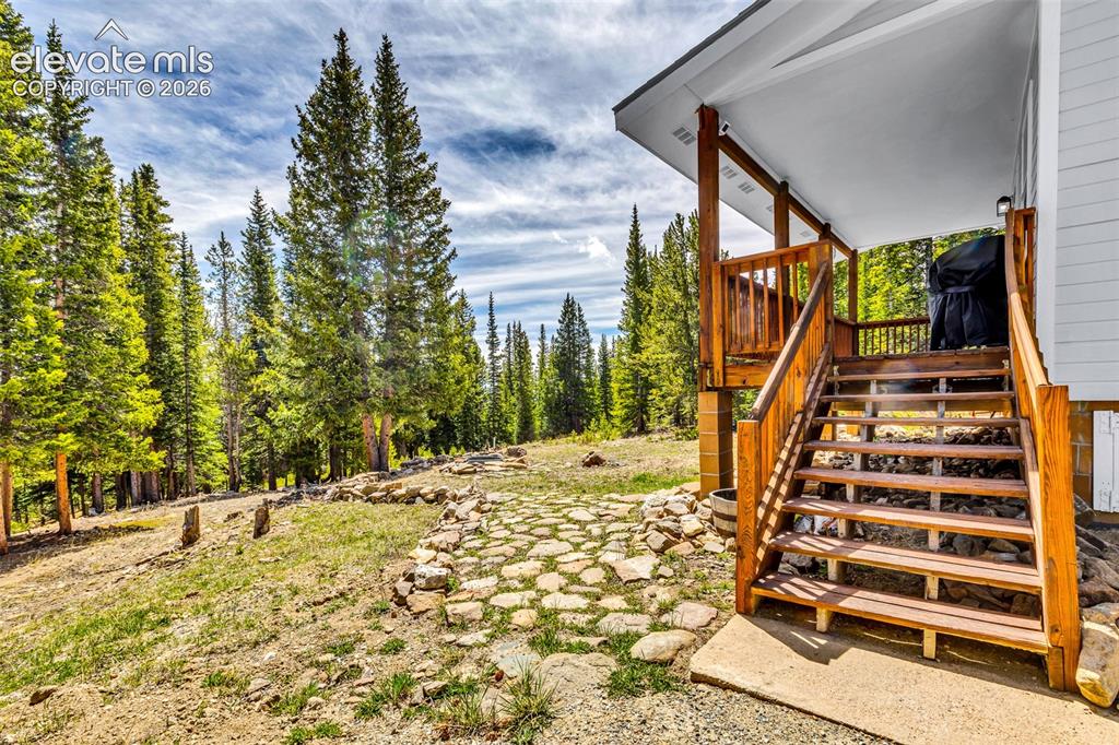 Image 21 of 37: Stained wood deck and stairs with a covered porch entry