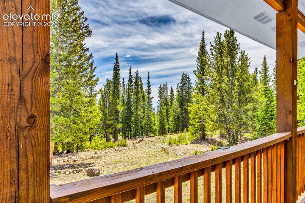 Image 24 of 37: Covered wood-finish porch with vertical balusters