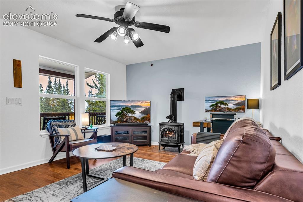 Image 5 of 37: Living area with wood-finish flooring, a ceiling fan with integrated lighti
