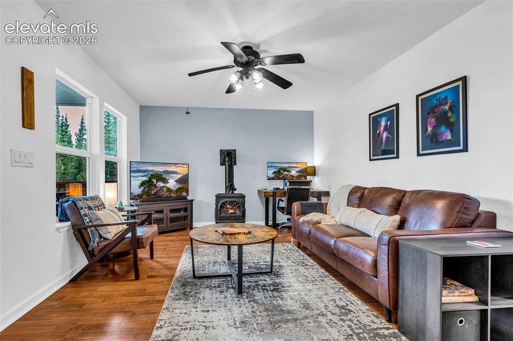 Image 6 of 37: Living area featuring wood-finish flooring, a vaulted ceiling, and a ceilin