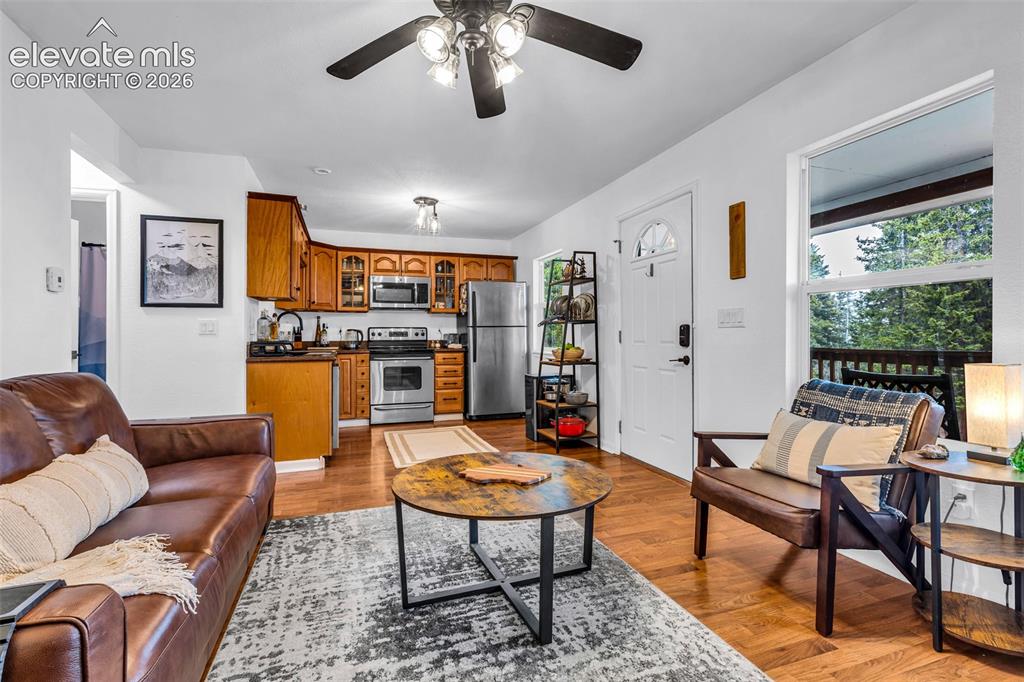 Image 8 of 37: Open-concept living space featuring wood-finish flooring, a kitchen with wo