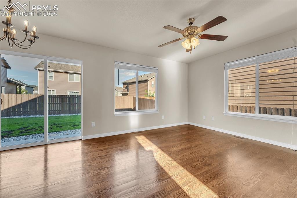 Image 10 of 28: Unfurnished room with a chandelier, wood finished floors, and ceiling fan